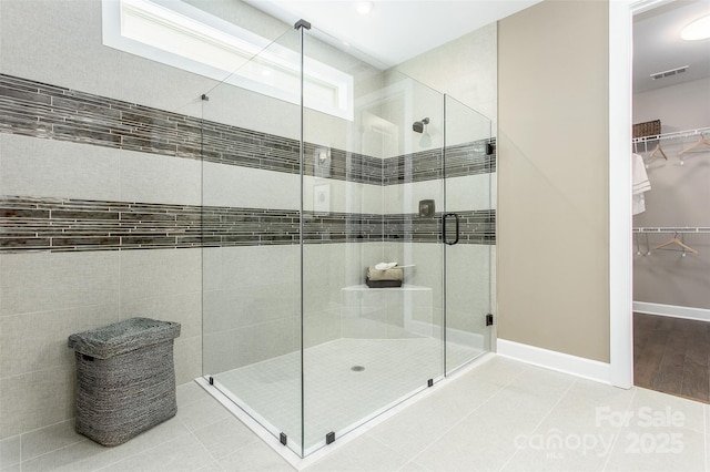 bathroom with tile patterned floors and a shower with door