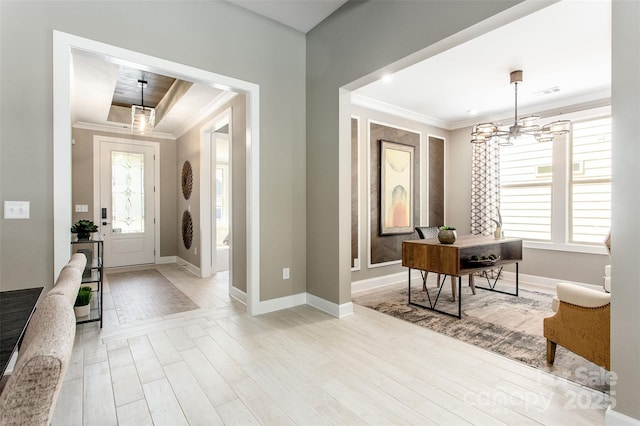 foyer featuring a wealth of natural light, crown molding, light wood-type flooring, and a notable chandelier