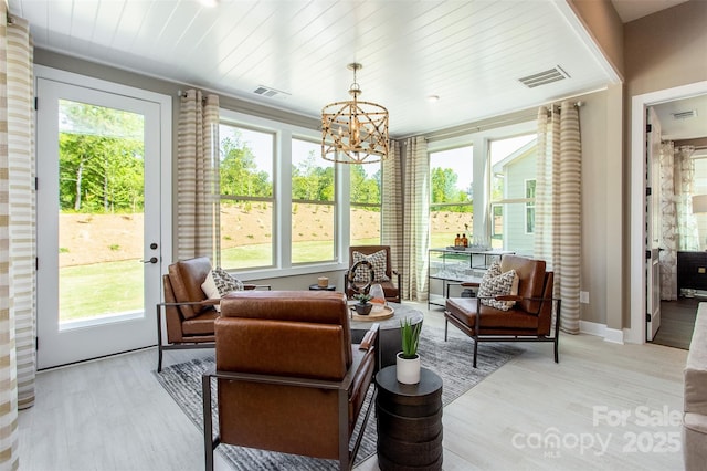 sunroom featuring a chandelier