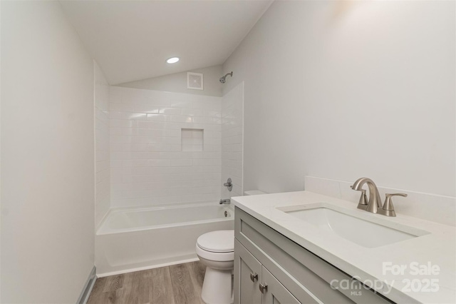 full bathroom with shower / bath combination, lofted ceiling, toilet, vanity, and hardwood / wood-style flooring