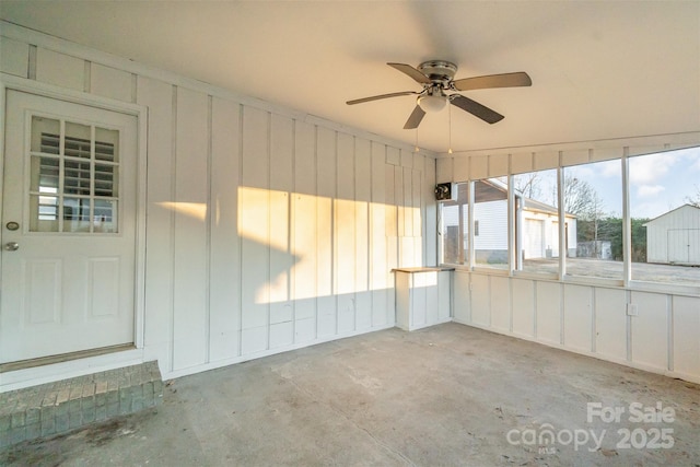 unfurnished sunroom with ceiling fan