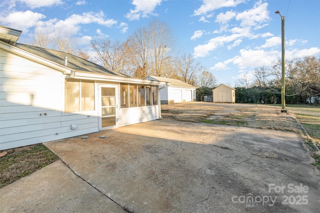 exterior space with a sunroom and a storage unit