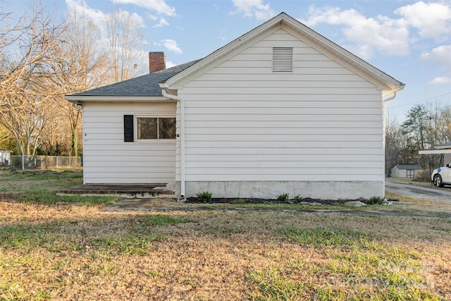 view of side of home with a lawn