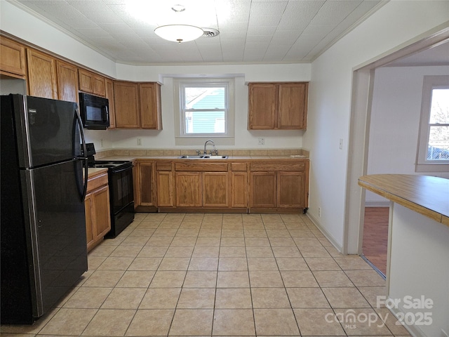 kitchen featuring sink, light tile patterned flooring, black appliances, and ornamental molding