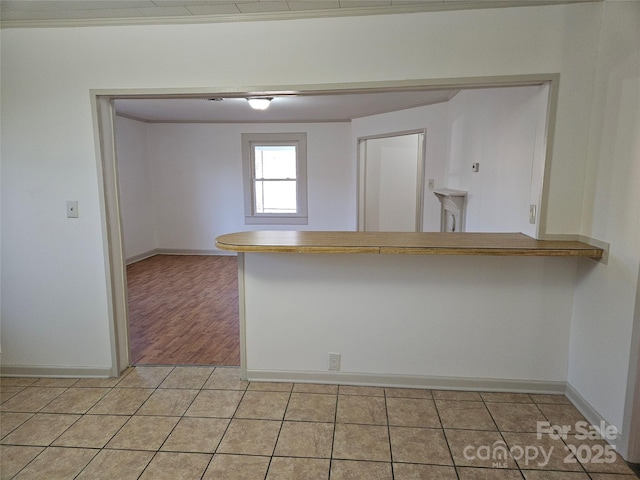 kitchen featuring light tile patterned flooring and kitchen peninsula