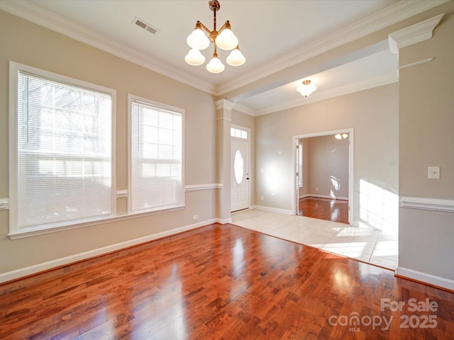 interior space with light hardwood / wood-style flooring, a chandelier, and crown molding