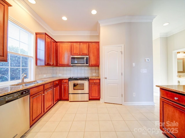 kitchen featuring light stone counters, sink, decorative backsplash, and appliances with stainless steel finishes