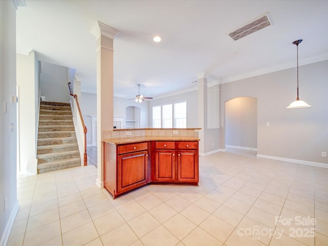 kitchen with ceiling fan, pendant lighting, ornamental molding, and ornate columns