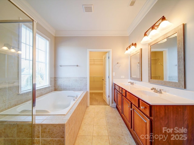 bathroom with ornamental molding, tile patterned floors, a relaxing tiled tub, and vanity