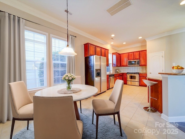 dining space with ornamental molding and light tile patterned flooring