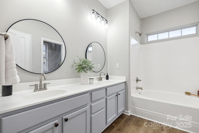 bathroom featuring hardwood / wood-style flooring, shower / tub combination, and vanity