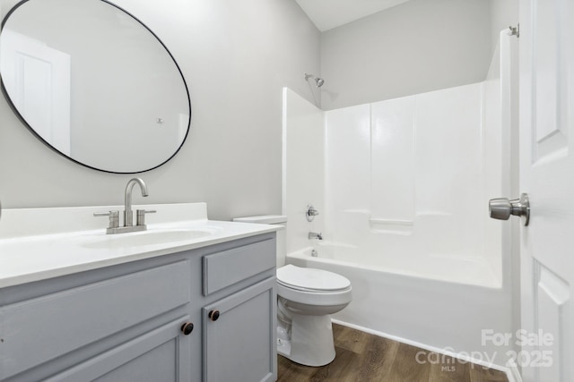 full bathroom featuring wood-type flooring, toilet, tub / shower combination, and vanity