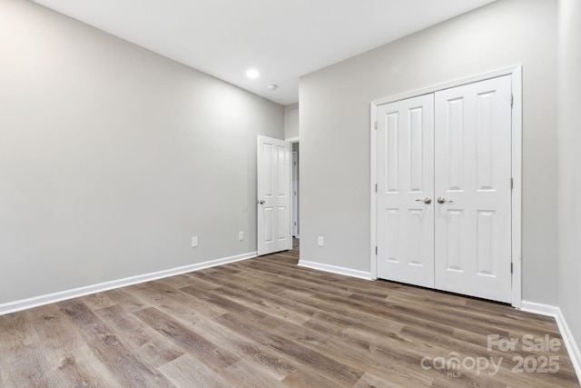 unfurnished bedroom with hardwood / wood-style flooring and a closet