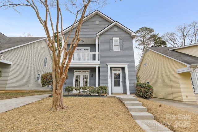 view of front of property with a balcony and a front yard