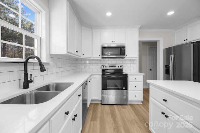 kitchen featuring stainless steel appliances, sink, and white cabinets