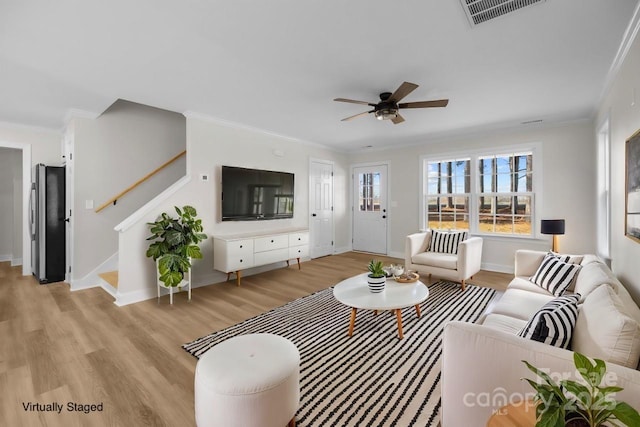 living room featuring ceiling fan, light wood-type flooring, and ornamental molding