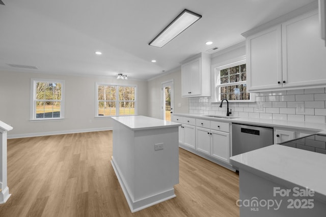 kitchen with sink, dishwasher, backsplash, a center island, and white cabinets