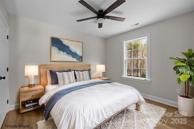 bedroom with dark hardwood / wood-style floors and ceiling fan