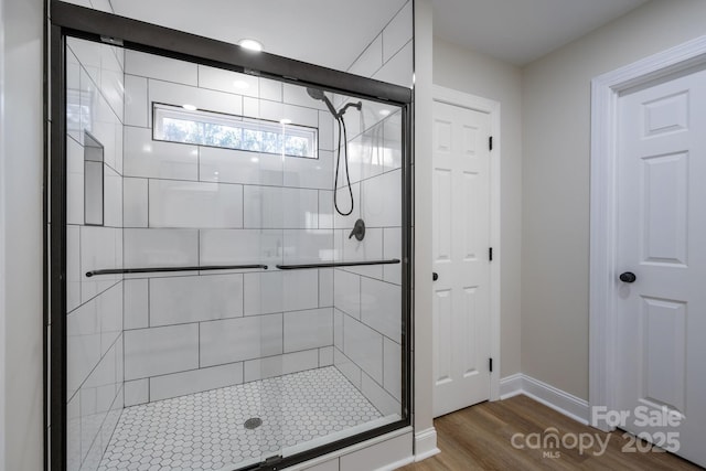 bathroom featuring hardwood / wood-style flooring and a shower with door