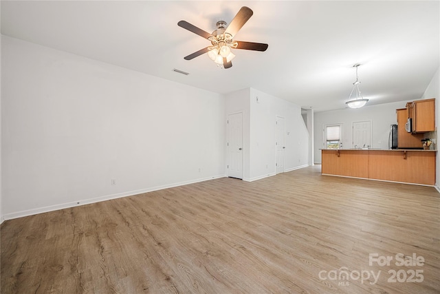 unfurnished living room with ceiling fan and light hardwood / wood-style floors