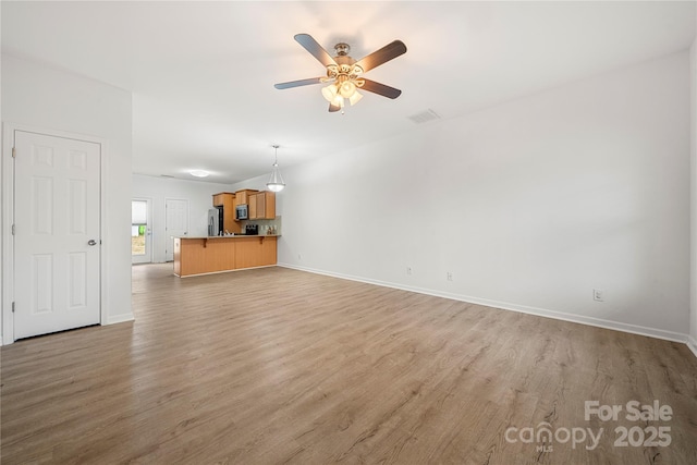 unfurnished living room with ceiling fan and light hardwood / wood-style flooring