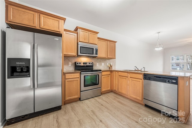 kitchen with sink, light hardwood / wood-style flooring, tasteful backsplash, kitchen peninsula, and stainless steel appliances