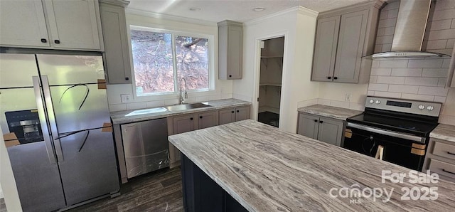 kitchen featuring appliances with stainless steel finishes, gray cabinetry, wall chimney exhaust hood, sink, and dark hardwood / wood-style floors