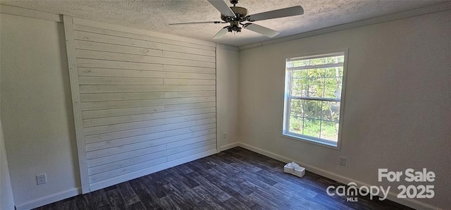 unfurnished room featuring ceiling fan, dark hardwood / wood-style floors, a textured ceiling, wooden walls, and ornamental molding