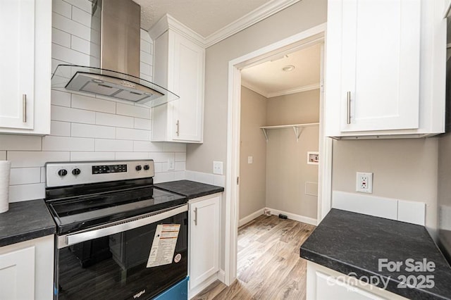 kitchen with wall chimney exhaust hood, crown molding, electric range, light hardwood / wood-style floors, and white cabinetry