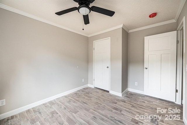 unfurnished bedroom featuring ceiling fan, light hardwood / wood-style flooring, a textured ceiling, and ornamental molding