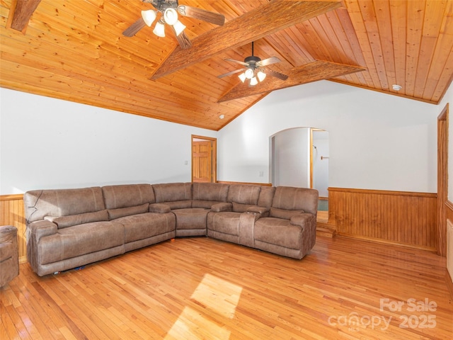 unfurnished living room featuring vaulted ceiling with beams, wood walls, light hardwood / wood-style flooring, and wood ceiling