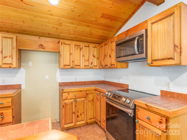 kitchen with wooden ceiling, range with electric cooktop, vaulted ceiling, tile counters, and light tile patterned flooring