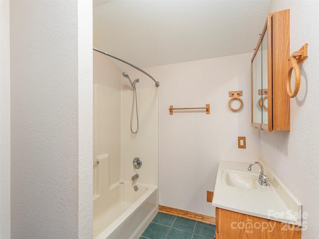 bathroom with a textured ceiling, tile patterned floors, vanity, and  shower combination