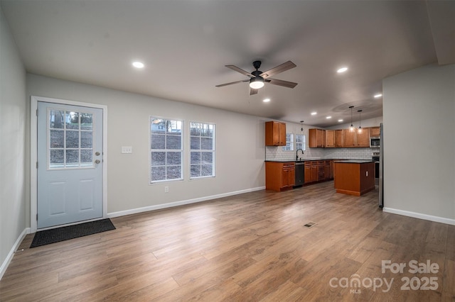 kitchen featuring pendant lighting, a center island, hardwood / wood-style flooring, decorative backsplash, and ceiling fan