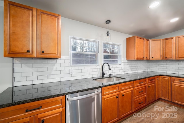 kitchen with backsplash, dishwasher, dark stone countertops, and sink