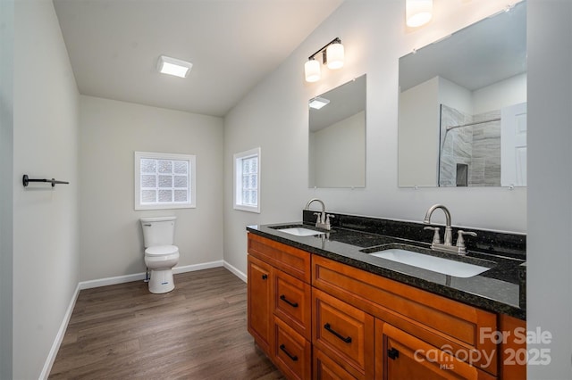 bathroom featuring a shower, wood-type flooring, vanity, and toilet