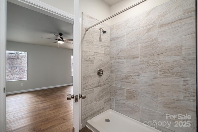 bathroom featuring ceiling fan, wood-type flooring, and tiled shower