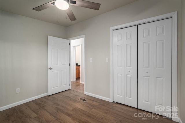 unfurnished bedroom with a closet, ceiling fan, and dark wood-type flooring