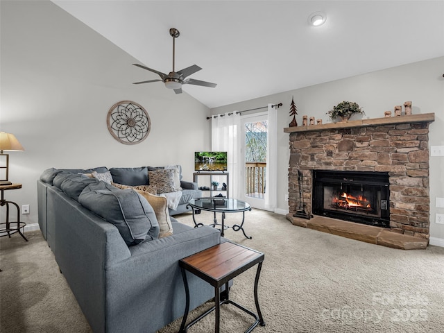 living room with carpet floors, a stone fireplace, ceiling fan, and lofted ceiling