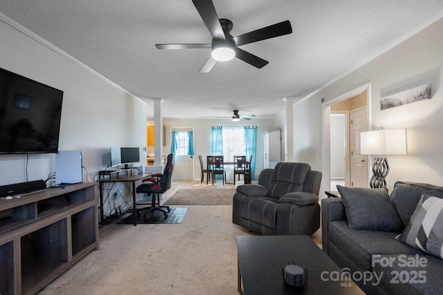 living room featuring a textured ceiling, ceiling fan, crown molding, and light carpet