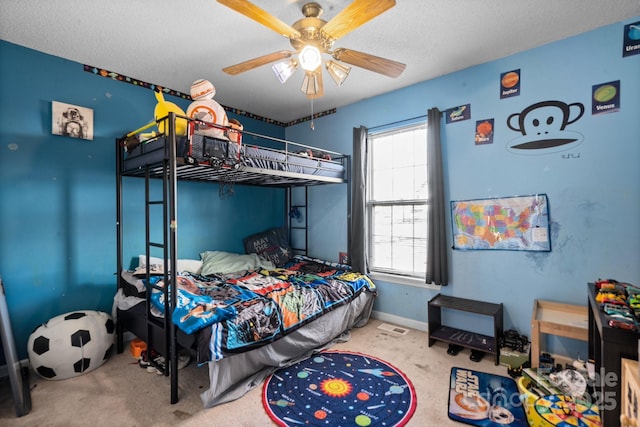 carpeted bedroom with ceiling fan and a textured ceiling