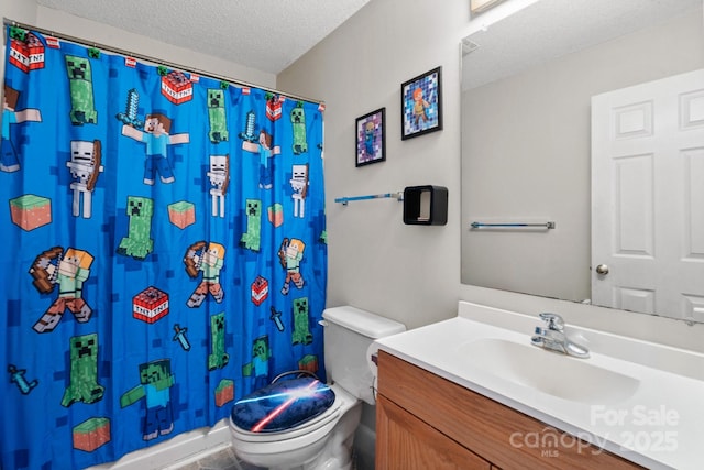 bathroom with a textured ceiling, a shower with shower curtain, vanity, and toilet