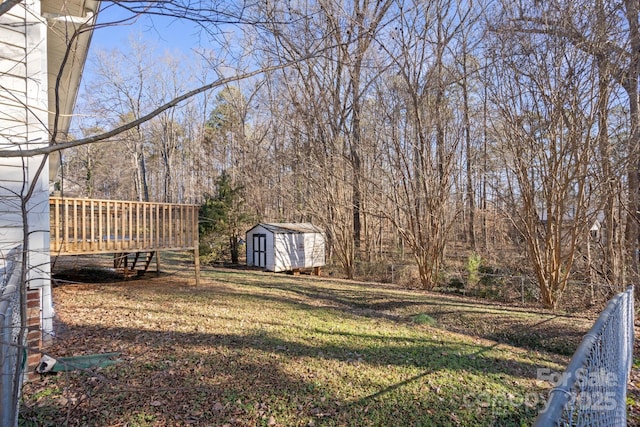 view of yard featuring a deck and a storage shed