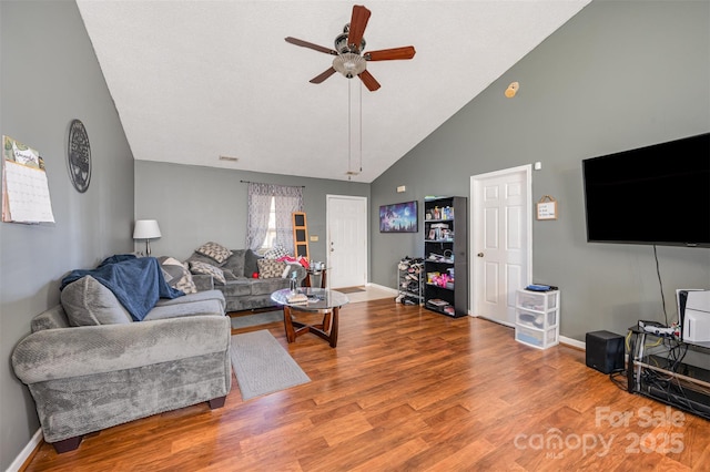 living room with hardwood / wood-style floors, high vaulted ceiling, and ceiling fan