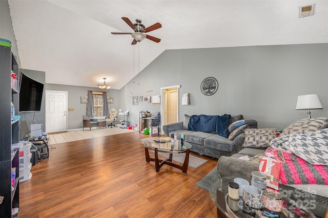 living room with a textured ceiling, ceiling fan with notable chandelier, wood-type flooring, and lofted ceiling