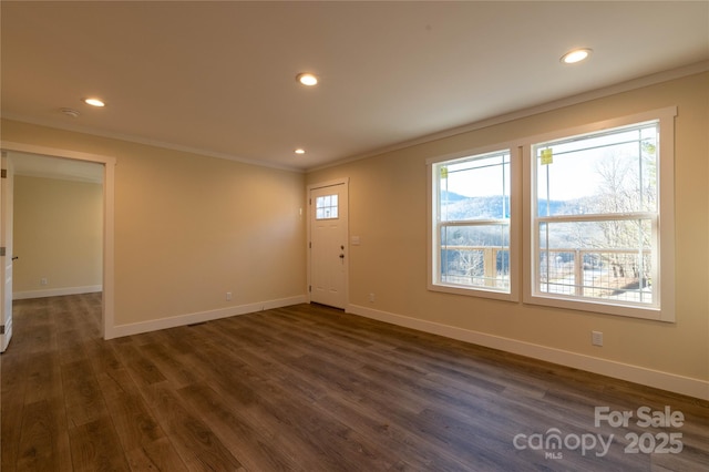 entrance foyer with dark hardwood / wood-style floors, a healthy amount of sunlight, and ornamental molding