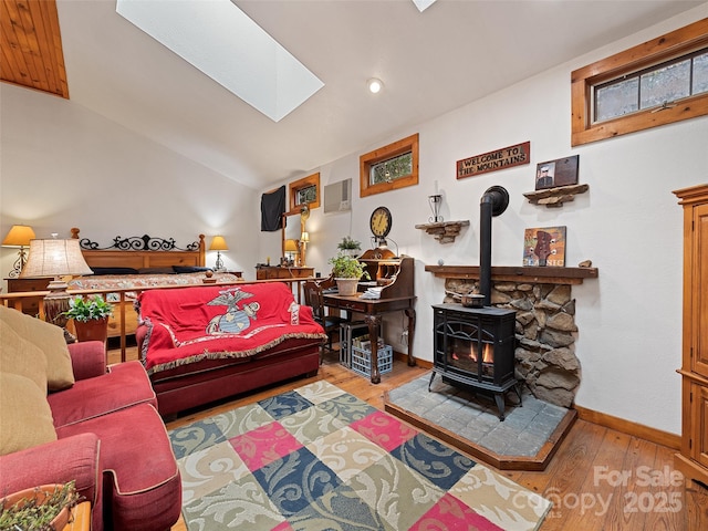 41 Cottontail Ln, Canton, NC 28716 - living room featuring wood finished floors, a wood stove, a skylight, vaulted ceiling, and baseboards