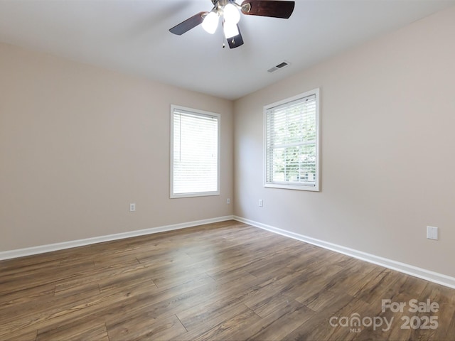 empty room featuring ceiling fan and dark hardwood / wood-style flooring