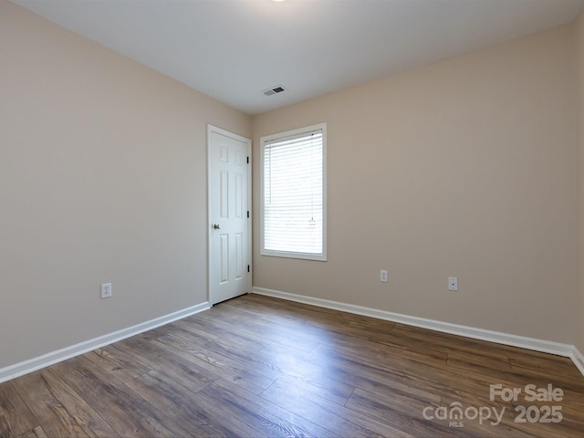 unfurnished room with dark wood-type flooring