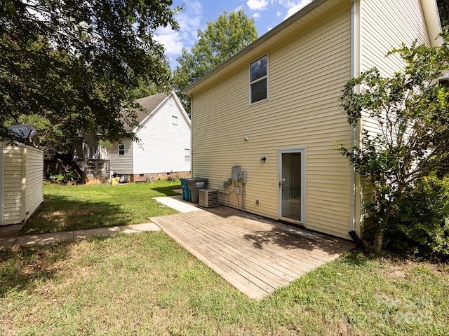 rear view of house featuring a lawn, a wooden deck, and central AC